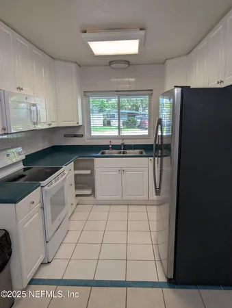a kitchen with a stove a sink and a refrigerator