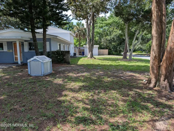 a view of a house with backyard and a tree