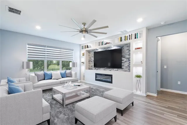 a living room with furniture a flat screen tv and a large window