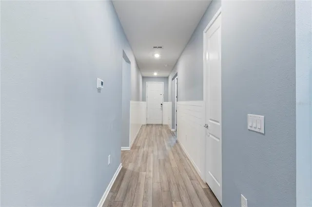 a view of a hallway with wooden floor