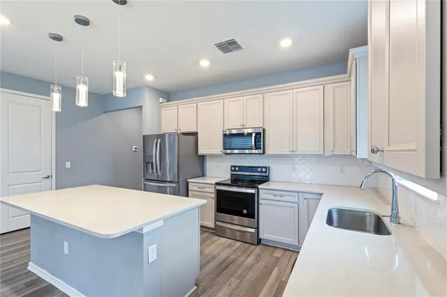 a kitchen with stainless steel appliances a stove a sink a microwave and cabinets