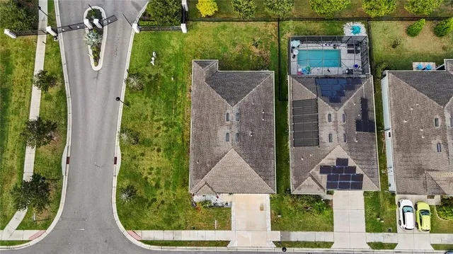 an aerial view of residential houses with outdoor space and lake view