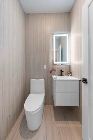 a bathroom with a sink mirror and toilet