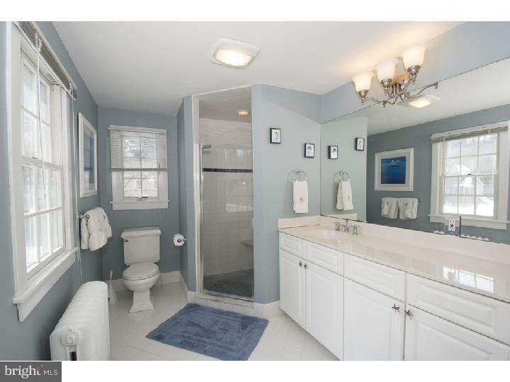 221 South Spring Mill Road Villanova, PA 19085 - Photo 22 of 25 a bathroom with a sink a toilet a large mirror and shower