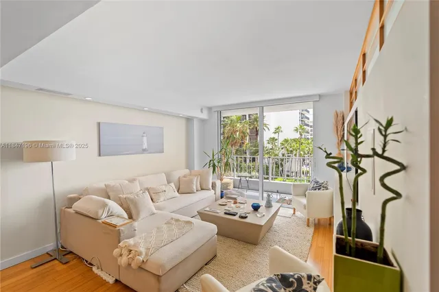 a living room with furniture a window and a flat screen tv