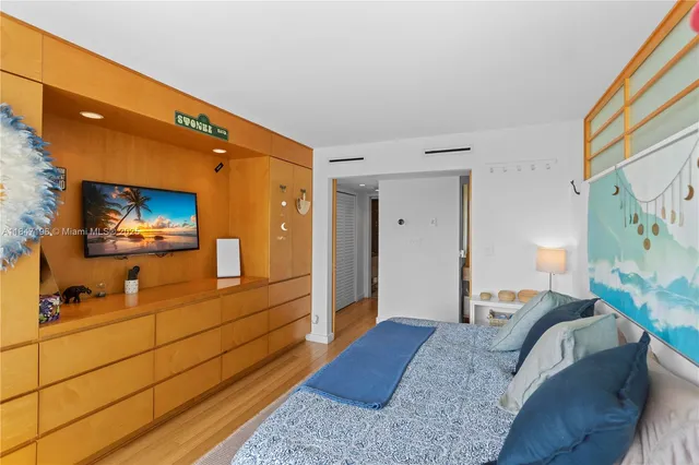 a bedroom with a bed and wooden floor