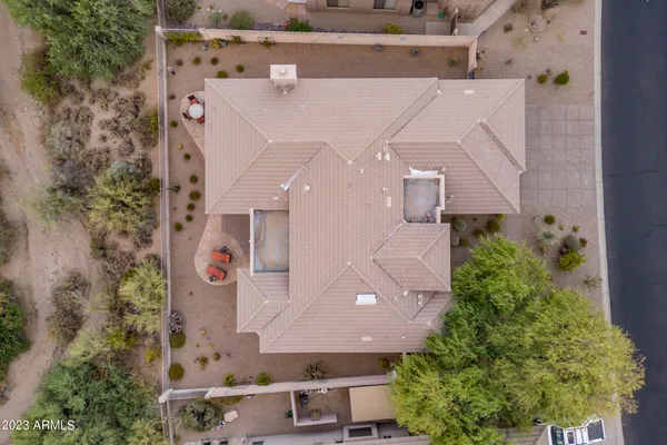 a view of a backyard with sitting area and tree