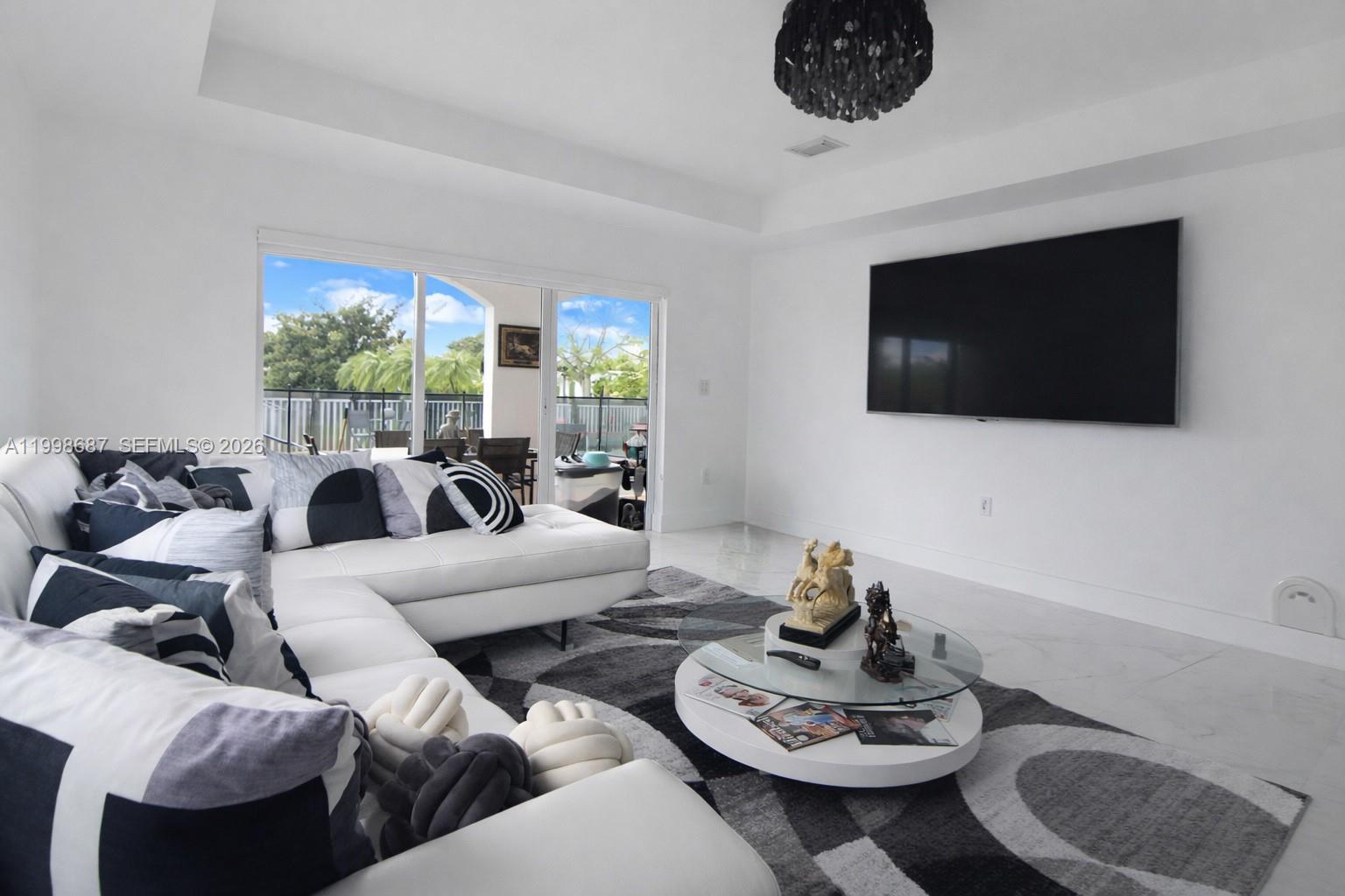 15045 Southwest 38th Terrace Miami, FL 33185 - Photo 12 of 37 a living room with furniture and a flat screen tv