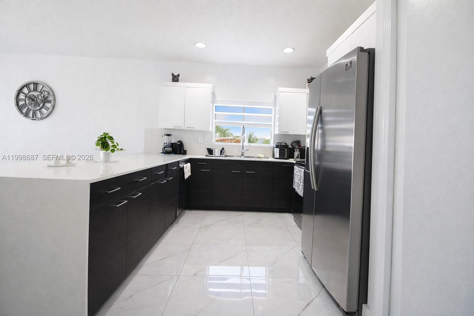 15045 Southwest 38th Terrace Miami, FL 33185 - Photo 16 of 37 a kitchen with stainless steel appliances a sink a counter top space cabinets and a window