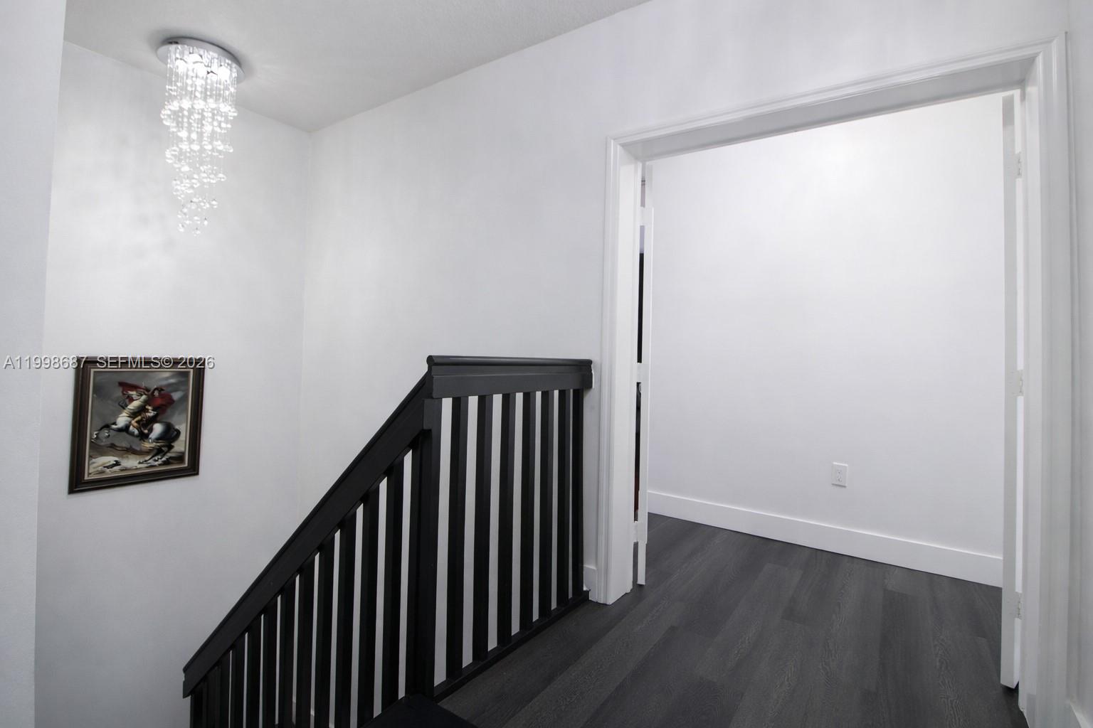 15045 Southwest 38th Terrace Miami, FL 33185 - Photo 18 of 37 a view of a hallway with wooden floor and a chandelier