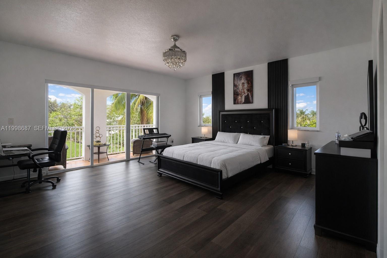15045 Southwest 38th Terrace Miami, FL 33185 - Photo 19 of 37 a bedroom with a balcony a bed and wooden floor
