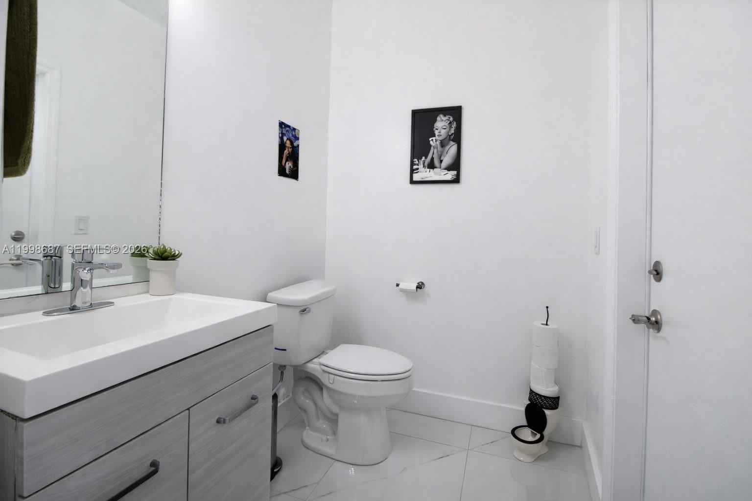 15045 Southwest 38th Terrace Miami, FL 33185 - Photo 25 of 37 a bathroom with a sink a toilet and a mirror