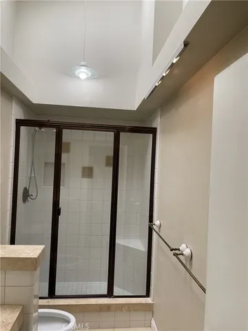 a view of a hallway with toilet and shower