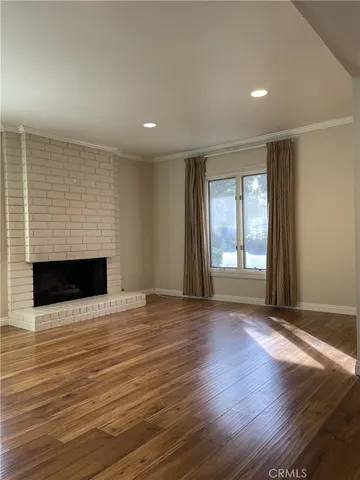 an empty room with wooden floor and fireplace