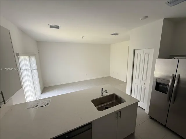 a kitchen that has a sink and a refrigerator