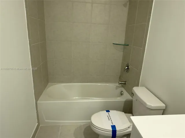 a bathroom with a toilet and a bath tub