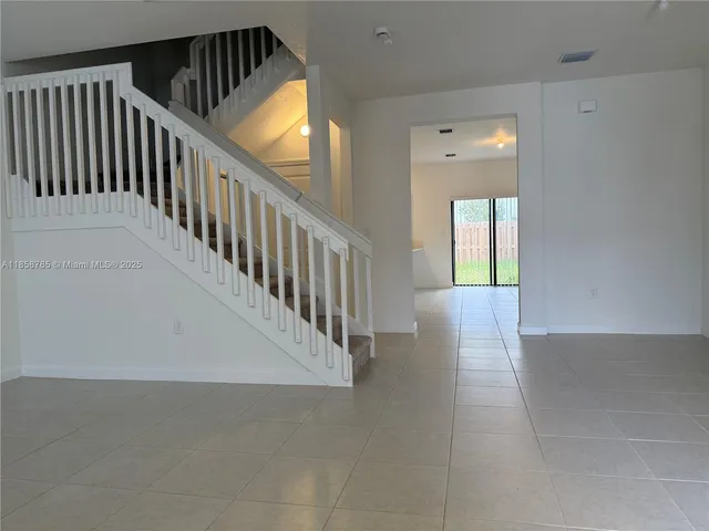 a view of staircase with railing and white walls