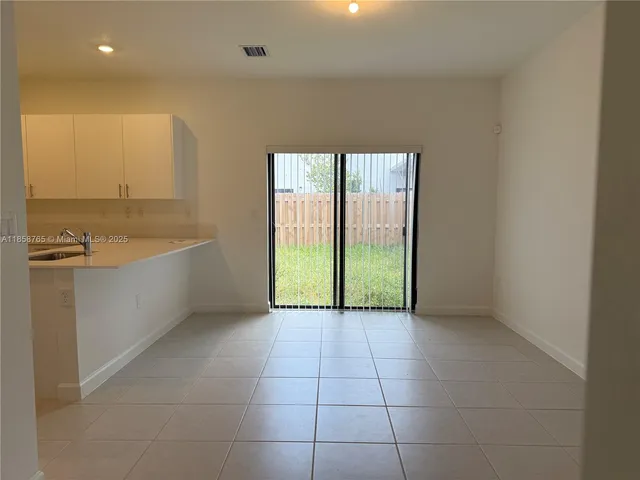 a view of an empty room with window and cabinet