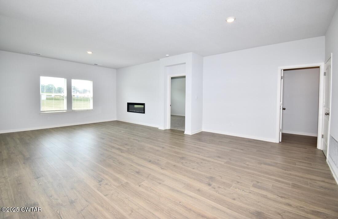 54 Clarendon Cove Jackson, TN 38305 - Photo 2 of 16 an empty room with wooden floor and windows