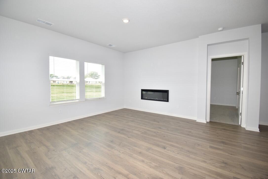 54 Clarendon Cove Jackson, TN 38305 - Photo 4 of 16 an empty room with wooden floor and windows
