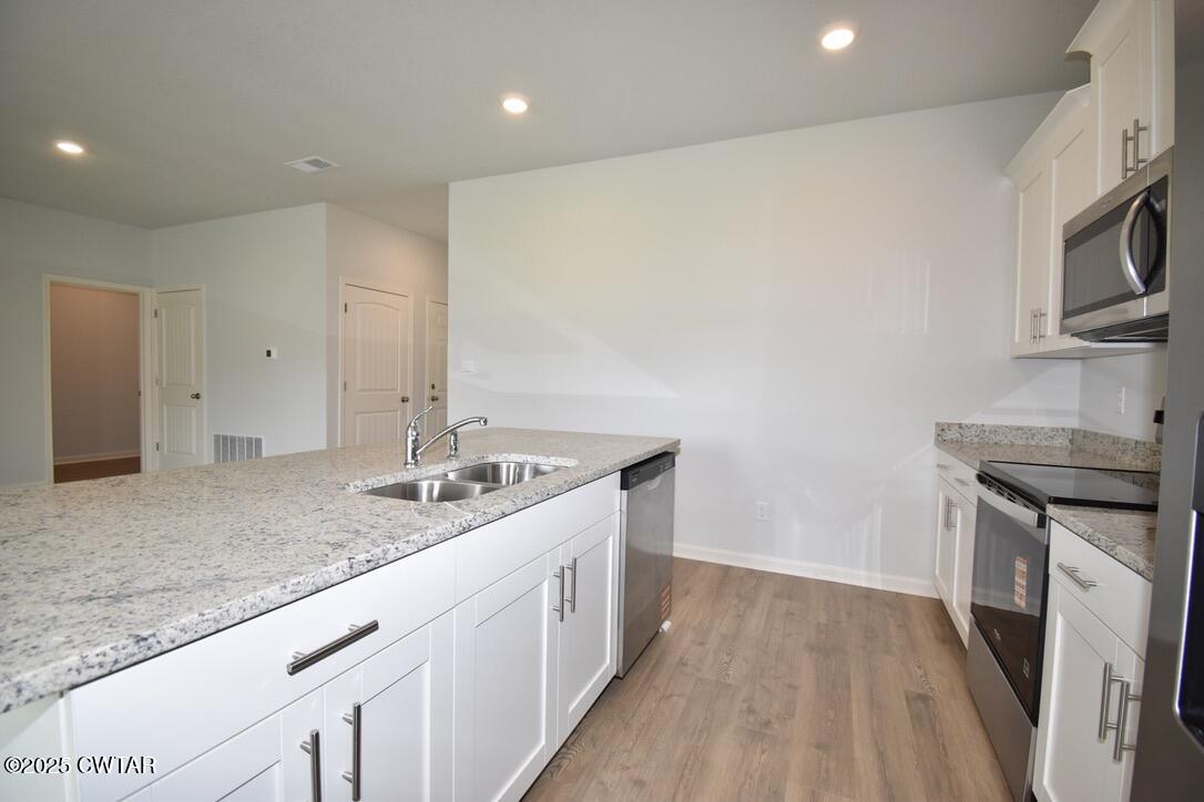 54 Clarendon Cove Jackson, TN 38305 - Photo 6 of 16 a kitchen with stainless steel appliances granite countertop a sink and stove top oven