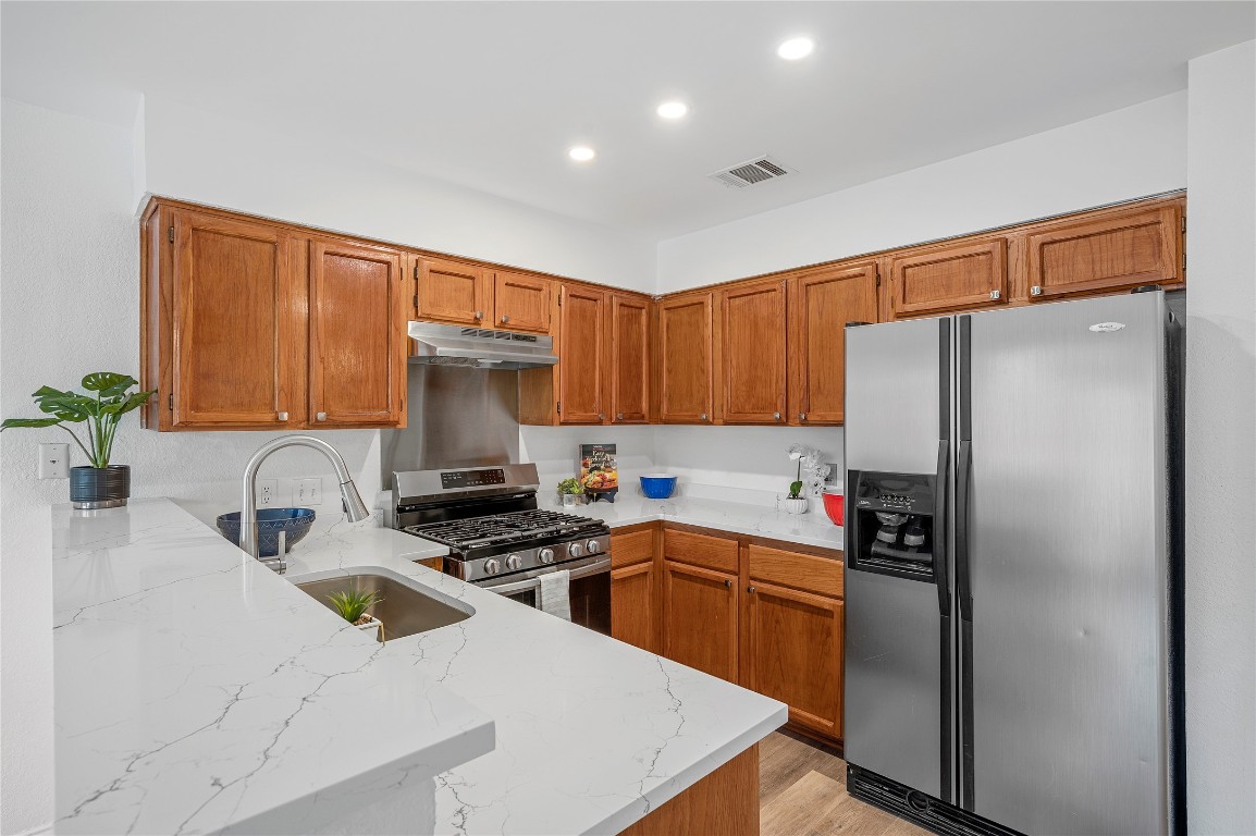 a kitchen with stainless steel appliances a refrigerator sink and cabinets