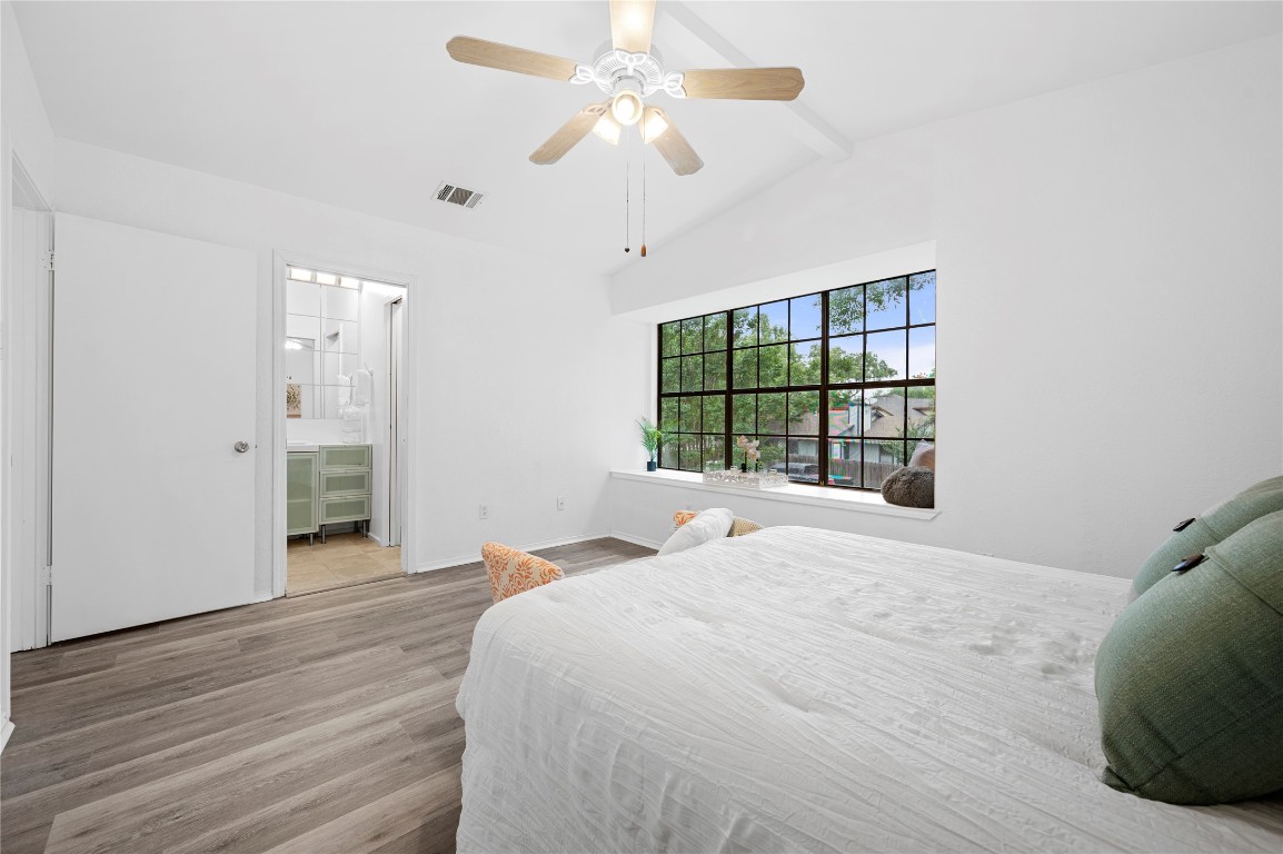 7705 Grovedale Trail Austin, TX 78729 - Photo 18 of 25 a bedroom with a large bed and a chandelier fan
