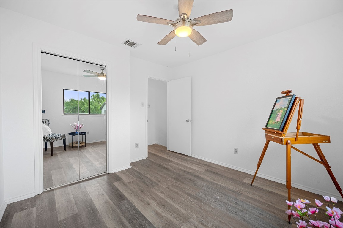7705 Grovedale Trail Austin, TX 78729 - Photo 21 of 25 a view of an empty room with wooden floor and a ceiling fan