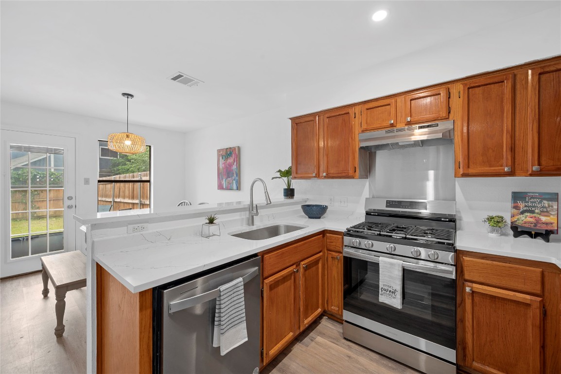 7705 Grovedale Trail Austin, TX 78729 - Photo 4 of 25 a kitchen with stainless steel appliances a sink stove and cabinets