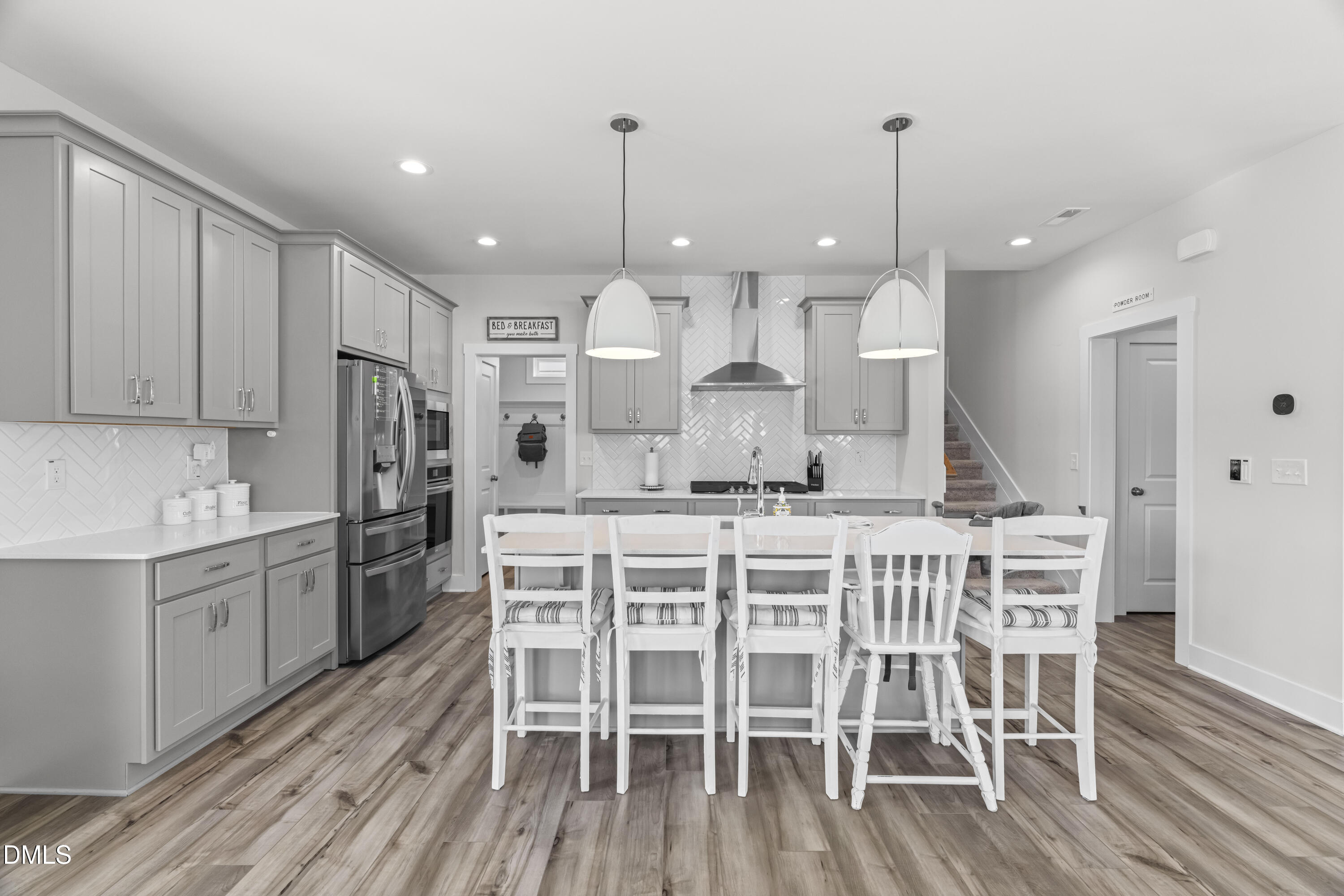 108 Bridge Street Smithfield, NC 27577 - Photo 10 of 48 a kitchen with stainless steel appliances kitchen island granite countertop a wooden floor and white cabinets