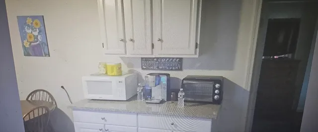a kitchen with white cabinets and sink