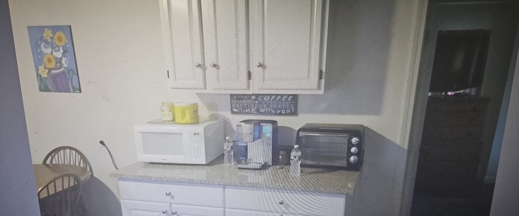 39 Union Street, Unit 1ST REAR Taunton, MA 02780 - Photo 4 of 5 a kitchen with white cabinets and sink
