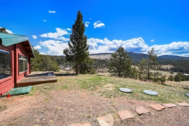 a view of a house with a yard and wooden fence
