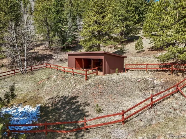 a view of wooden house with a large trees