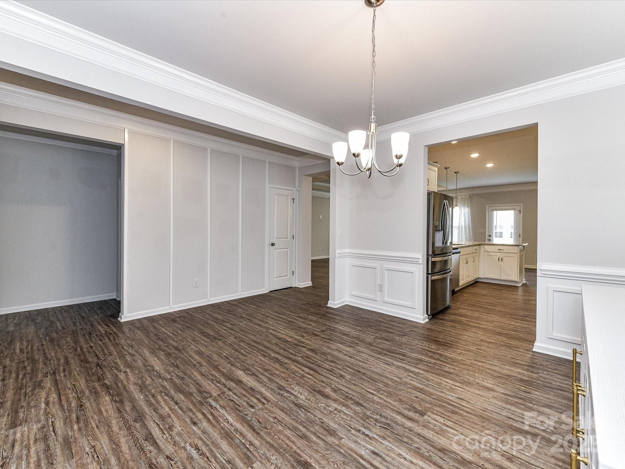 6168 Busch Way Midland, NC 28107 - Photo 8 of 42 a view of a livingroom with wooden floor staircase and a kitchen space