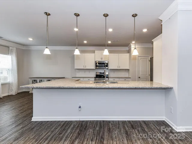 a large kitchen with stainless steel appliances granite countertop a lot of counter space sink and cabinets