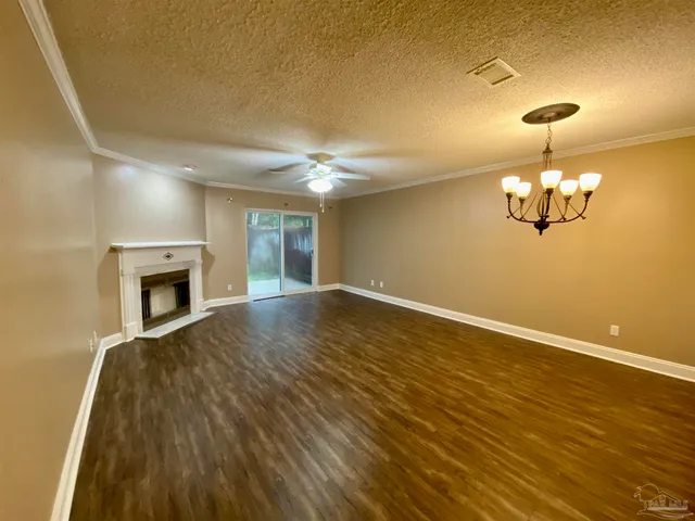 a view of empty room with wooden floor and fireplace