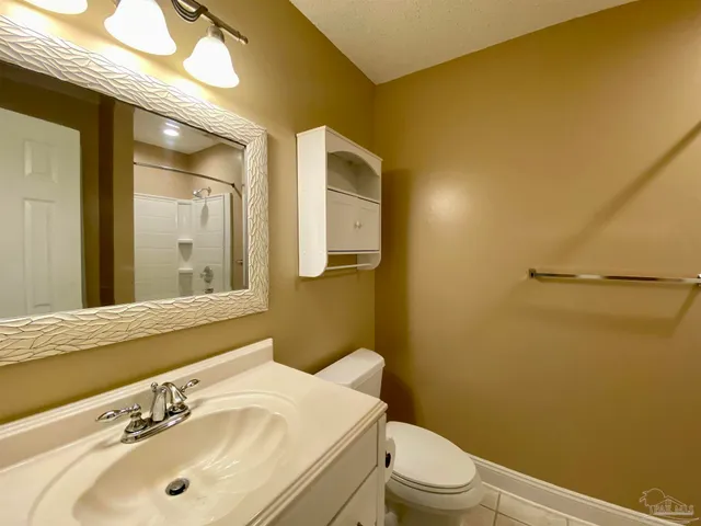 a bathroom with a sink mirror vanity and toilet