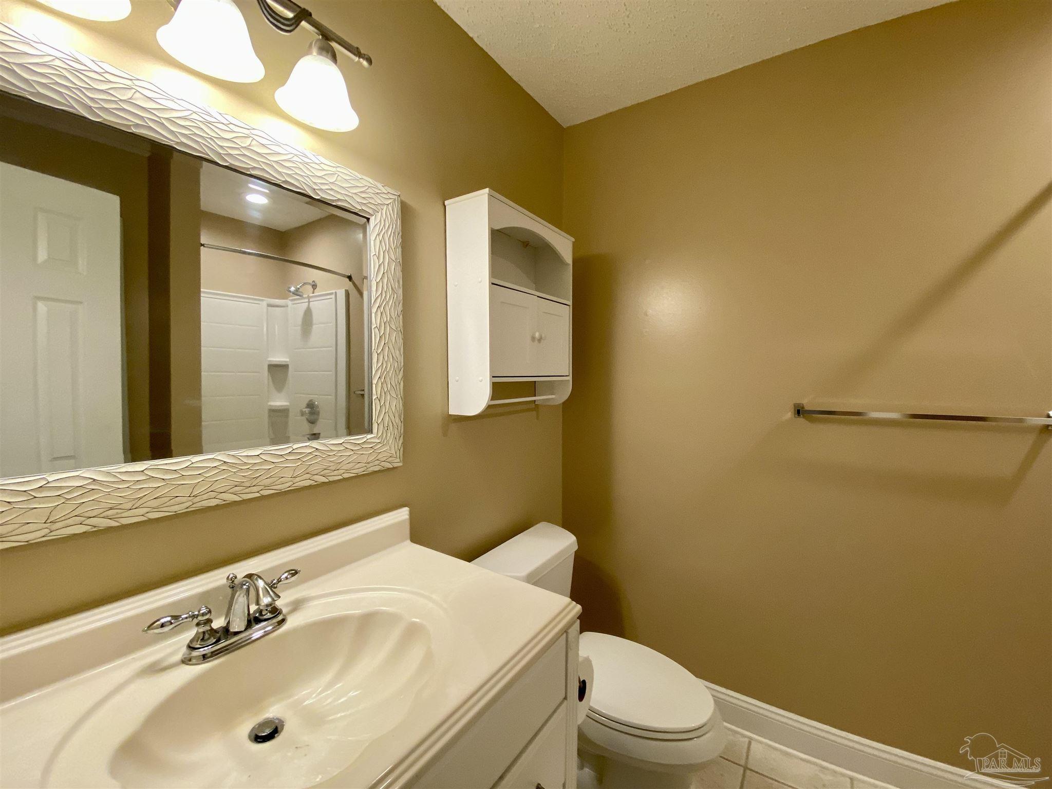 9022 Governors Pl Court Pensacola, FL 32514 - Photo 9 of 16 a bathroom with a sink mirror vanity and toilet