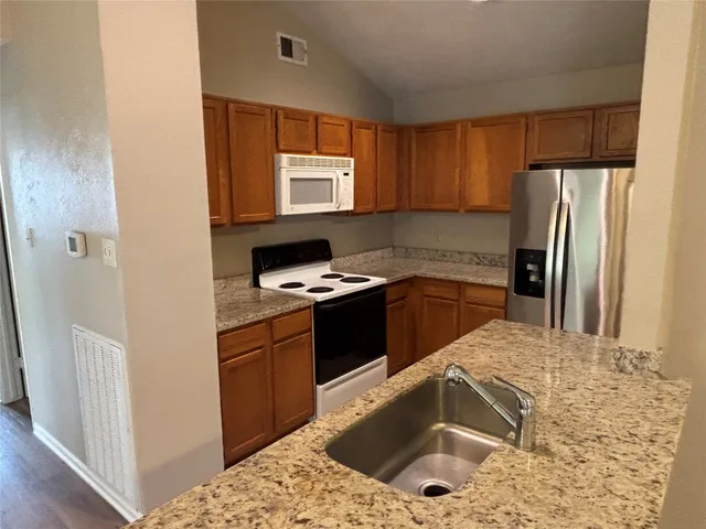 a kitchen with a sink stove and refrigerator