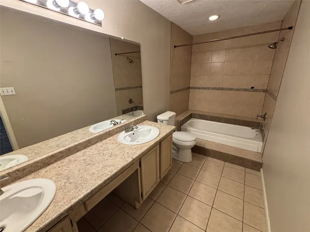 a bathroom with a granite countertop sink a toilet and shower