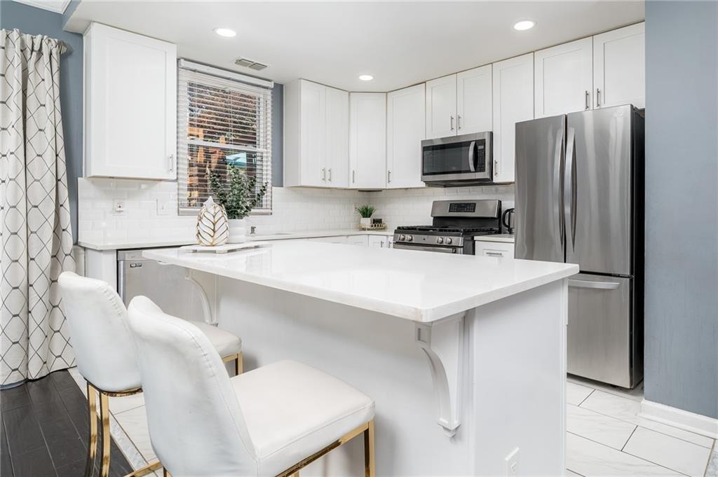 3539 Mt Vernon Circle Atlanta, GA 30340 - Photo 8 of 15 a kitchen with stainless steel appliances a sink a microwave a refrigerator and cabinets