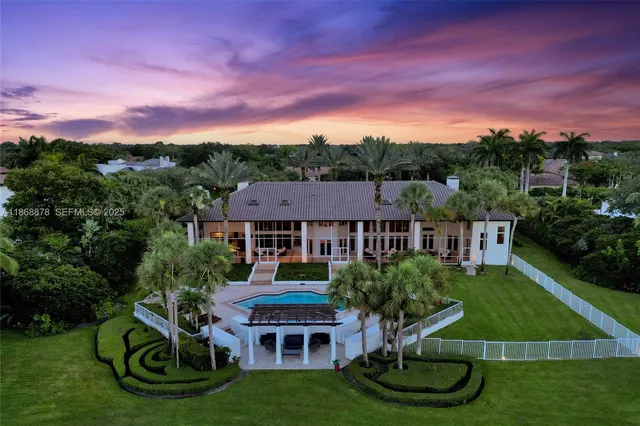 a front view of a house with garden and trees