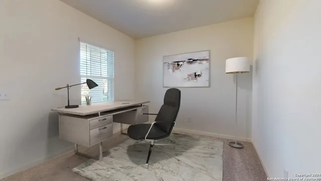 a view of a workspace with furniture and window