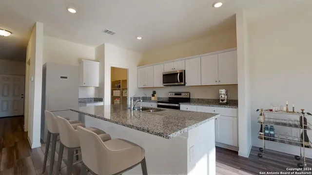 a kitchen with granite countertop kitchen island a sink appliances and cabinets