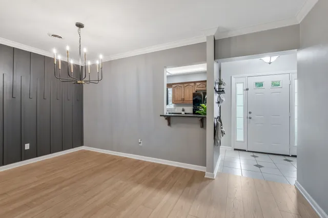 a view of a hallway with wooden floor and chandelier