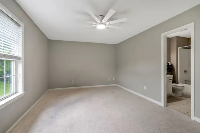 an empty room with closet and windows