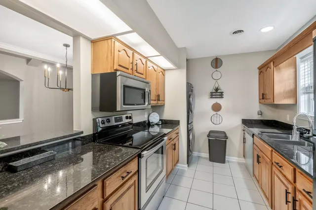 a kitchen with stainless steel appliances granite countertop a stove a sink and a microwave