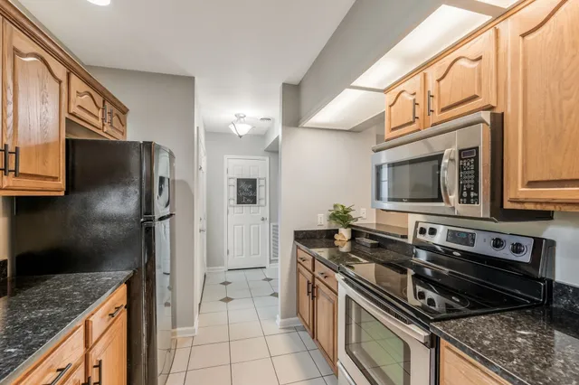 a kitchen with stainless steel appliances granite countertop a stove a refrigerator and a oven