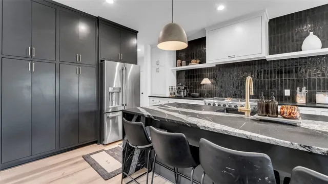 a kitchen with stainless steel appliances granite countertop a sink refrigerator and cabinets